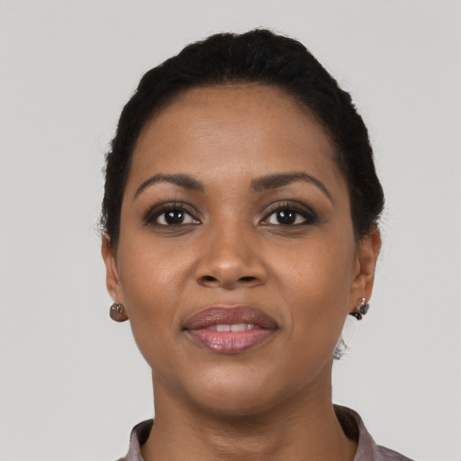 Joyful black young-adult female with short  black hair and brown eyes