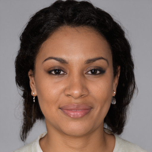 Joyful black adult female with medium  brown hair and brown eyes