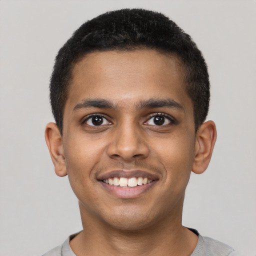 Joyful black young-adult male with short  black hair and brown eyes