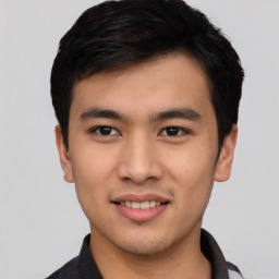 Joyful asian young-adult male with short  black hair and brown eyes