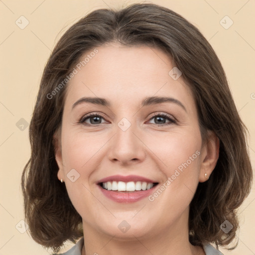 Joyful white young-adult female with medium  brown hair and grey eyes