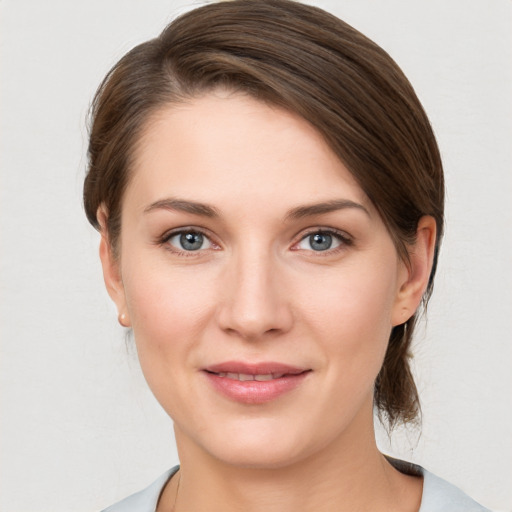 Joyful white young-adult female with medium  brown hair and grey eyes