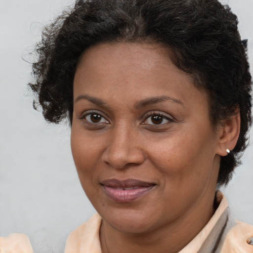 Joyful latino adult female with short  brown hair and brown eyes