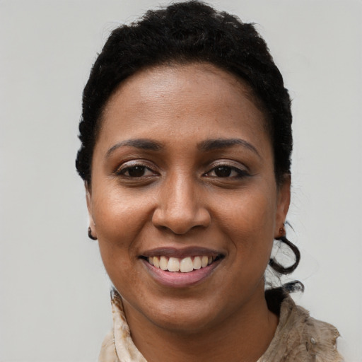 Joyful black young-adult female with long  black hair and brown eyes