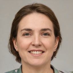 Joyful white adult female with medium  brown hair and grey eyes