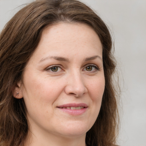 Joyful white adult female with long  brown hair and grey eyes