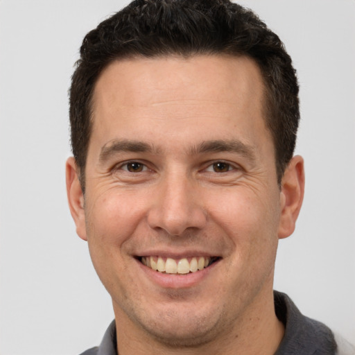 Joyful white adult male with short  brown hair and brown eyes