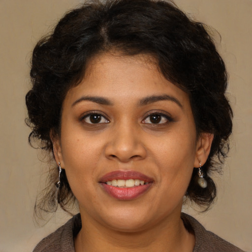 Joyful black young-adult female with medium  brown hair and brown eyes