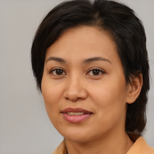 Joyful asian adult female with medium  brown hair and brown eyes