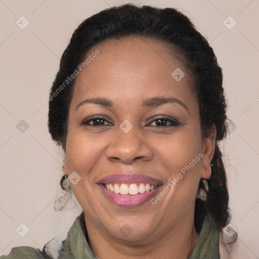 Joyful black adult female with long  brown hair and brown eyes