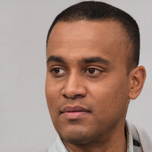 Joyful black young-adult male with short  black hair and brown eyes