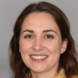 Joyful white adult female with medium  brown hair and brown eyes