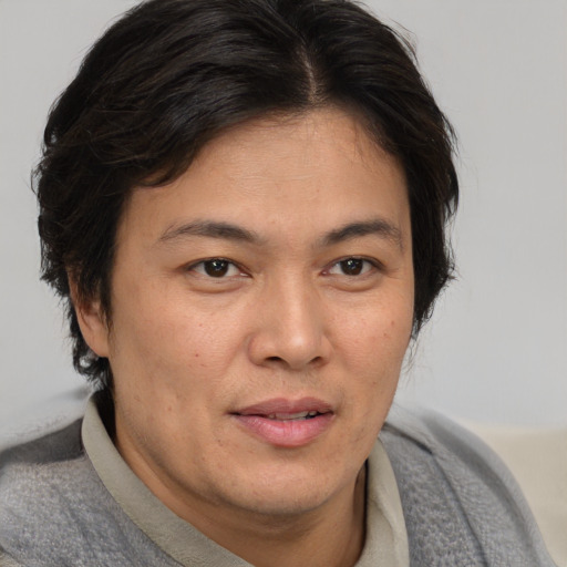 Joyful asian adult male with short  brown hair and brown eyes