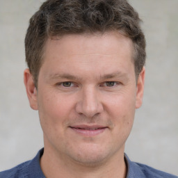 Joyful white adult male with short  brown hair and grey eyes