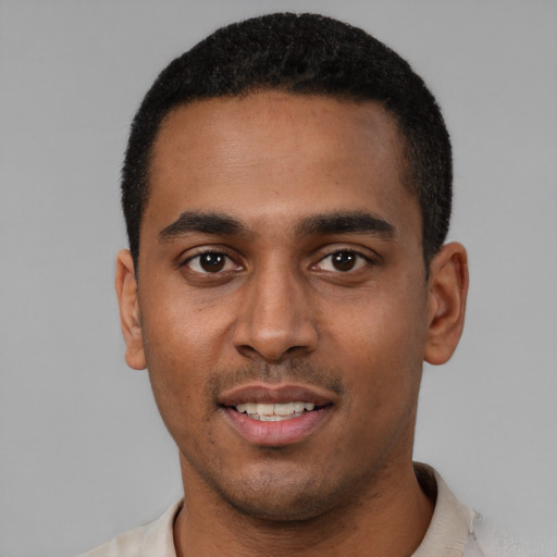 Joyful black young-adult male with short  black hair and brown eyes