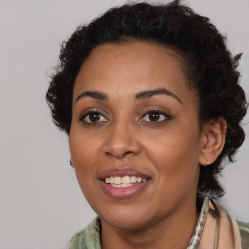 Joyful black young-adult female with short  brown hair and brown eyes