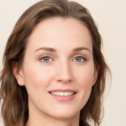 Joyful white young-adult female with long  brown hair and blue eyes