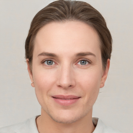 Joyful white young-adult female with short  brown hair and grey eyes