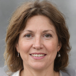 Joyful white adult female with medium  brown hair and grey eyes