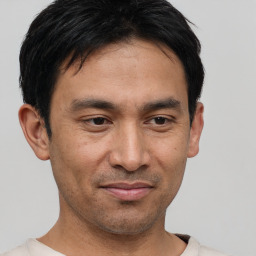 Joyful asian young-adult male with short  black hair and brown eyes