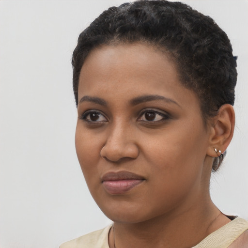 Joyful black young-adult female with short  black hair and brown eyes