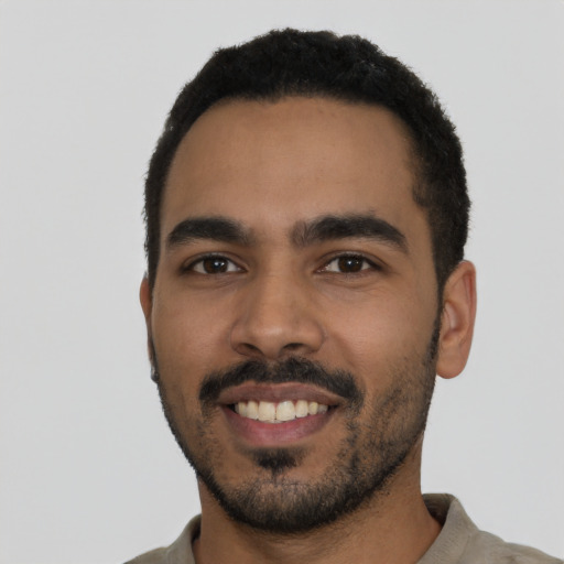 Joyful latino young-adult male with short  black hair and brown eyes