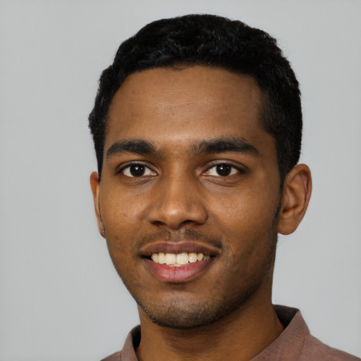 Joyful black young-adult male with short  black hair and brown eyes