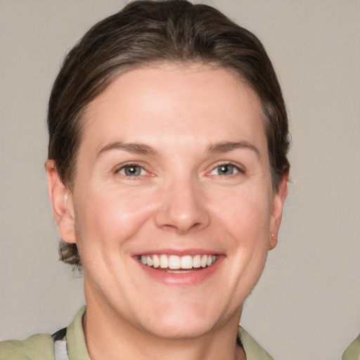 Joyful white adult female with medium  brown hair and grey eyes