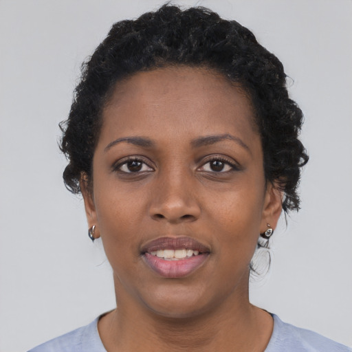 Joyful black young-adult female with short  black hair and brown eyes