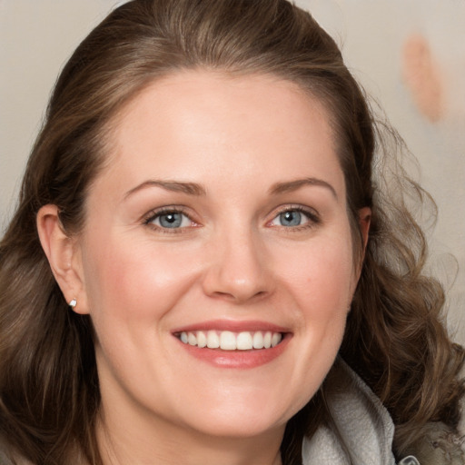 Joyful white adult female with medium  brown hair and blue eyes