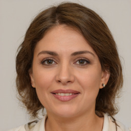 Joyful white adult female with medium  brown hair and brown eyes