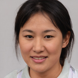 Joyful asian young-adult female with medium  brown hair and brown eyes