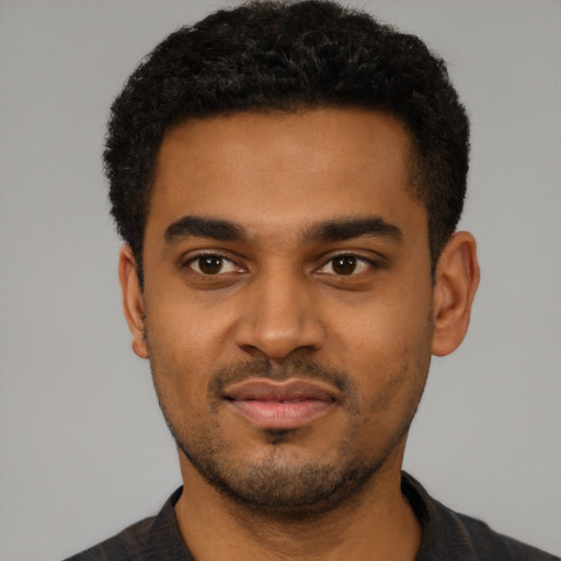 Joyful black young-adult male with short  black hair and brown eyes