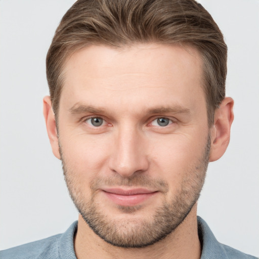 Joyful white young-adult male with short  brown hair and grey eyes