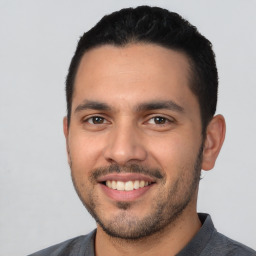 Joyful latino young-adult male with short  black hair and brown eyes