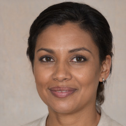 Joyful black adult female with medium  brown hair and brown eyes