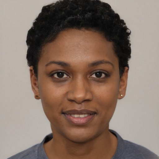 Joyful black young-adult female with short  black hair and brown eyes