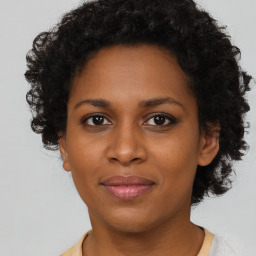 Joyful black adult female with short  brown hair and brown eyes