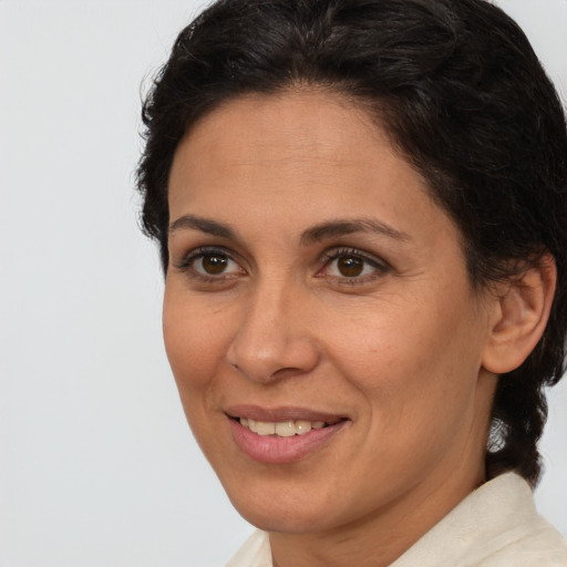 Joyful latino adult female with medium  brown hair and brown eyes