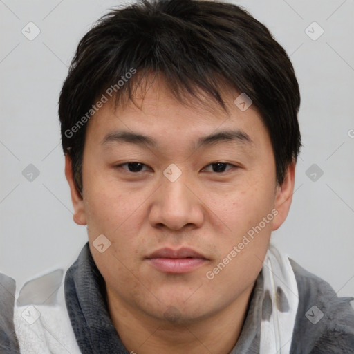 Joyful asian young-adult male with short  brown hair and brown eyes