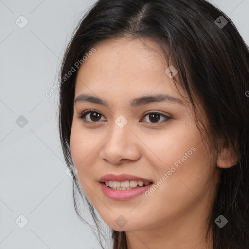 Joyful asian young-adult female with long  brown hair and brown eyes