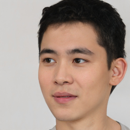 Joyful asian young-adult male with short  black hair and brown eyes