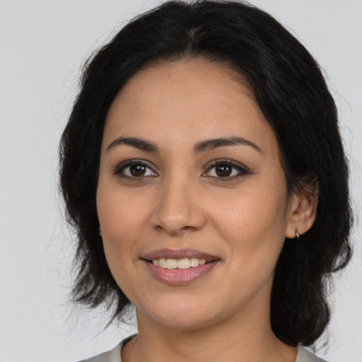 Joyful latino young-adult female with medium  brown hair and brown eyes