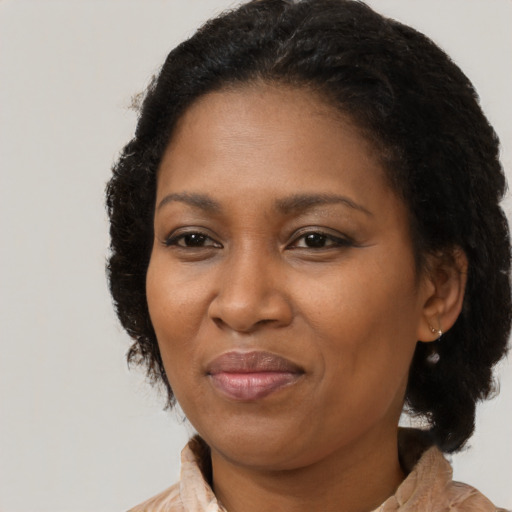 Joyful black adult female with long  brown hair and brown eyes
