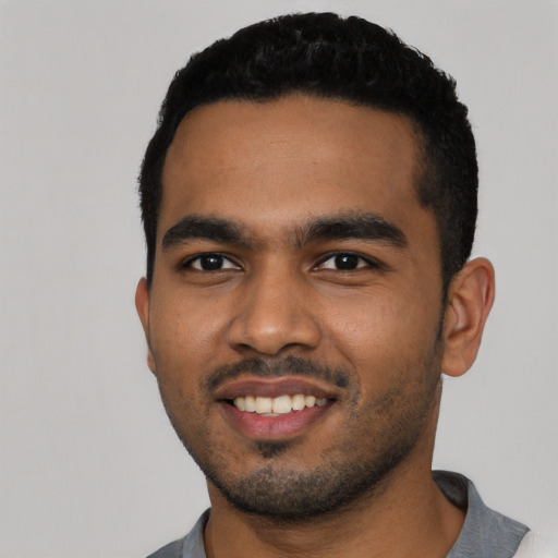 Joyful black young-adult male with short  black hair and brown eyes