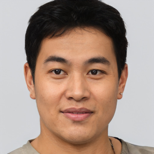 Joyful asian young-adult male with short  brown hair and brown eyes