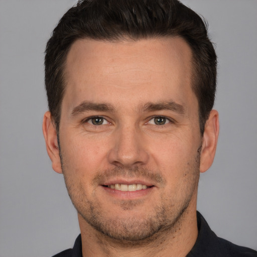 Joyful white adult male with short  brown hair and brown eyes