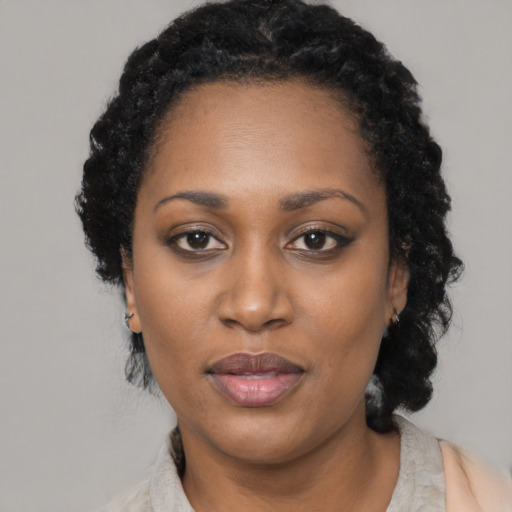 Joyful black adult female with short  black hair and brown eyes