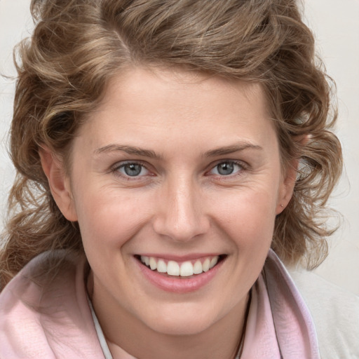 Joyful white young-adult female with medium  brown hair and blue eyes