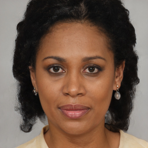 Joyful black adult female with medium  brown hair and brown eyes
